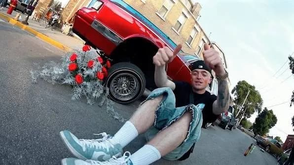 Artist posing by a lowrider